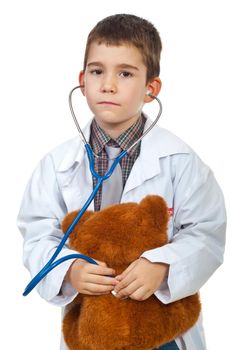 Future doctor boy examine his teddy bear with stethoscope isolated on white background