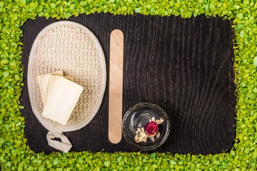 spa products: black mud and clay powder, soap, bath salt on black wood table background. Still life. Top view. Copy space