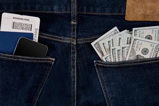 Dollars, smart, passport and plane ticket in your pocket jeans. Top view. Copy space. Still life. Flat lay