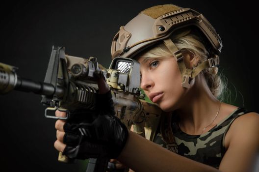 girl soldier armed with an automatic rifle takes aim