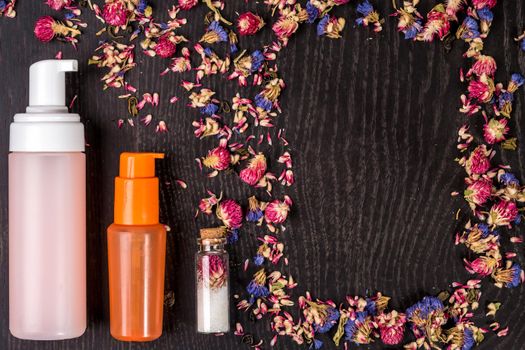 Petals, dry flowers and women's accessories on black background. Flat lay, Top view. Copy space