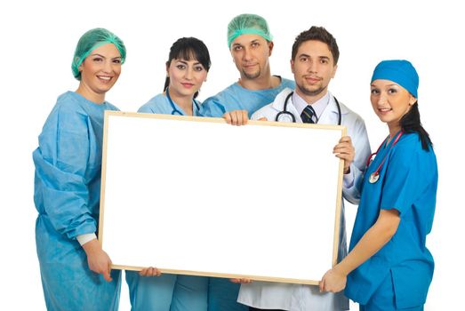 Cheerful team of five doctors holding a blank banner isolated on white background
