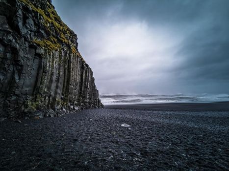 The basaltic beach with cloudy stormy sky