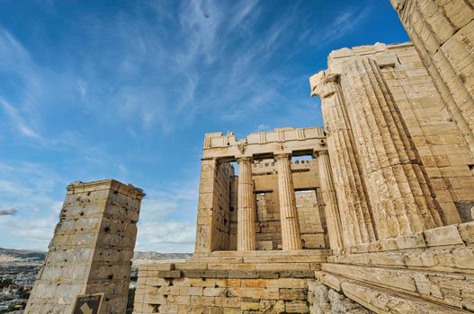 Athens Acropolis, Greece landmark. Ancient Greek Propylaea entrance gate ceiling and pillars low angle view, blue sky, spring sunny day.