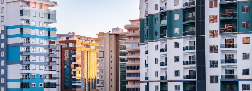 Fragments of facades of modern multi-storey residential buildings, side view, close-up. Banner