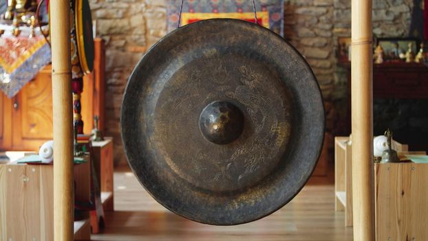 Asian religious metal gong to alert monks of prayer time - religion, tradition and lifestyle concept.