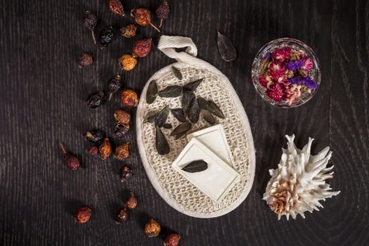 natural soap, dried flowers, sponge and shell on a black background. Still life