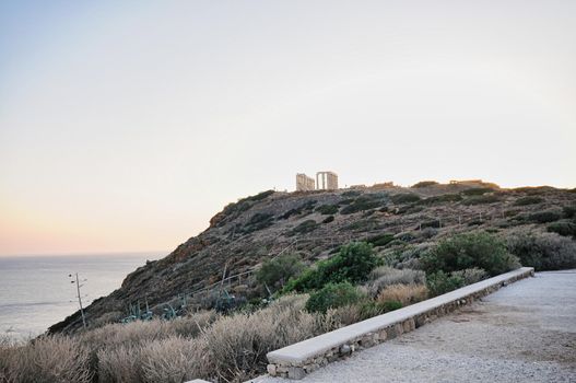 the ancient temple of Poseidon . Cape Sounion , located 69 kilometers of Athens , Greece . The site is a popular day-excursion for tourists from Athens