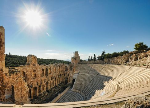 Ancient Odeon of Herodes Atticus in Athens, Greece on Acropolis hill with view over the city, sunset light and selective focus