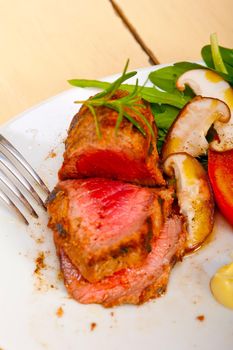 beef filet mignon grilled with fresh vegetables on side ,mushrooms tomato and arugula salad