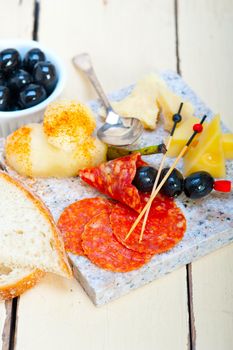 cold cut assortment cheese salami and fresh pears served on a granite stone