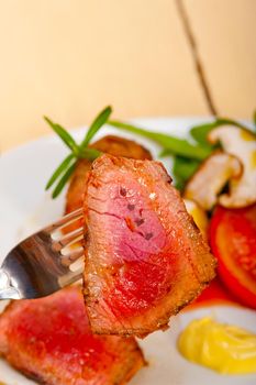 beef filet mignon grilled with fresh vegetables on side ,mushrooms tomato and arugula salad