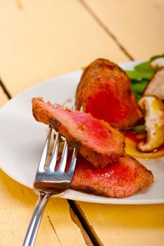 beef filet mignon grilled with fresh vegetables on side ,mushrooms tomato and arugula salad