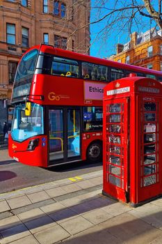 London, United Kingdom, February 8, 2022: the famous red double-decker bus and the red telephone booth on a London street