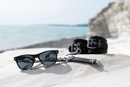 the leather handcuffs for bdsm sex toys on the beach while on vacation in summer