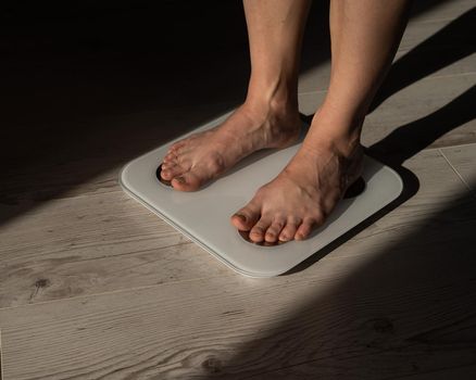 Close-up of female legs on electronic scales