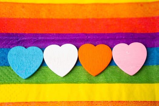 Wooden hearts on LGBT rainbow colorful cloth, a symbol of lesbian, gay, bisexual, transgender, human rights, tolerance and peace.