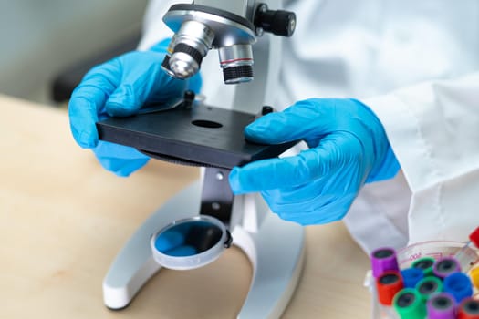 Asian scientist biochemist or microbiologist working research with a microscope in laboratory. For protect outbreak Coronavirus Covid19, bacteria and germs.