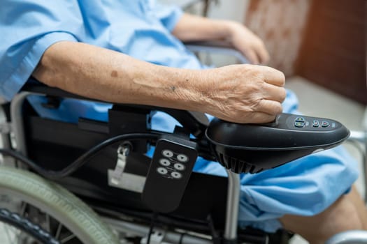 Asian senior or elderly old lady woman patient on electric wheelchair with remote control at nursing hospital ward, healthy strong medical concept