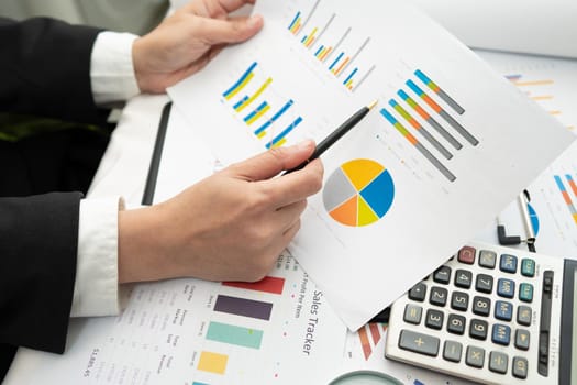 Asian accountant working and analyzing financial reports project accounting with chart graph and calculator in modern office,finance and business concept.