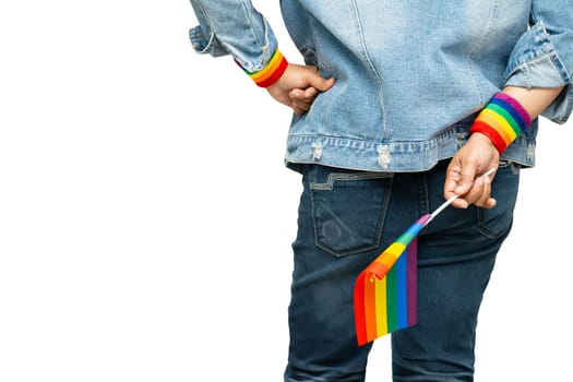 Asian lady wearing blue jean jacket or denim shirt and holding rainbow color flag, symbol of LGBT pride month celebrate annual in June social of gay, lesbian, bisexual, transgender, human rights.