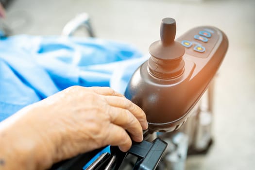 Asian senior or elderly old lady woman patient on electric wheelchair with remote control at nursing hospital ward, healthy strong medical concept