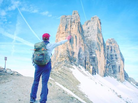 Backpacker on trip aound  Tre Cime di Lavaredo in sunny April  morning. View from tour around popular massive, Dolomite Alps,  Italy