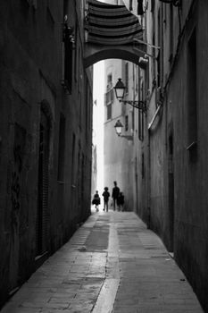 People walking in an alley in old town in Barcelona in black and white