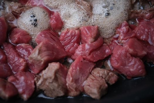 Pieces of pork or beef are fried in pan in oil. Recipes for fried and stewed meat in pan concept