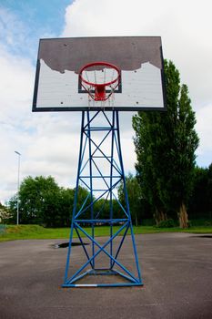 Old worn basketball hoopand  blue sky in background