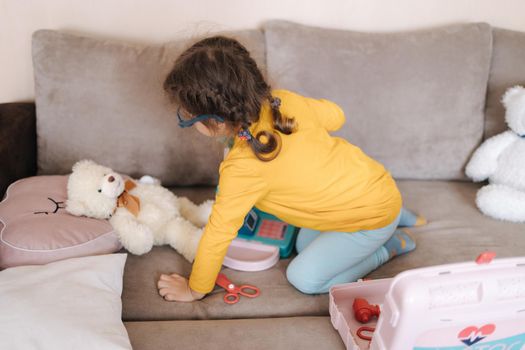 Happy adorable girl playing doctor