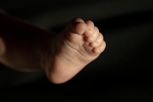 Baby foot and a dark background