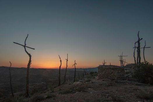 Crosses forming a memorial reminding a fire that burned a forest in Catalonia in a sunset landscape