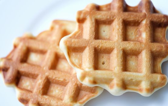 Homemade Belgian sugar waffles on plate. Cooking delicious waffles at home concept