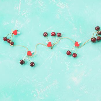 Ripe red sweet cherries arranged in the shape of a big heart on grungy table. Romantic love concept.