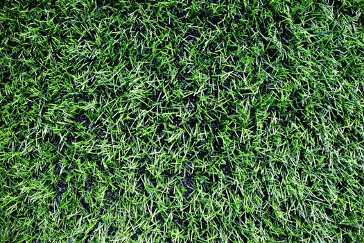 View into plastic grass, artificial green turf texture background