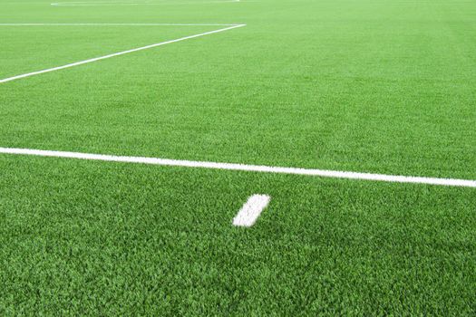 White lines on football playground. Detail of lines in a field. Plastic grass and finely ground black rubber. 