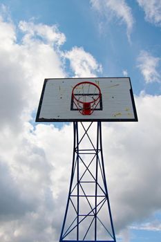 Old worn basketball hoopand  blue sky in background