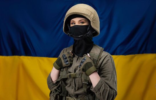 girl Ukrainian soldier on the background of the flag of Ukraine, wearing a helmet and a bulletproof vest