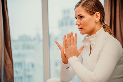 Athletic slim caucasian woman doing thigh self-massage with a massage ball indoors. Self-isolating massage.