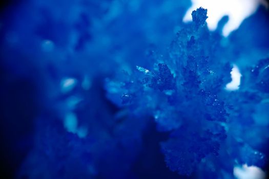 Blue frozen ice in beautiful sapphires and crystals. Frozen natural winter texture. Crystallization of frozen ice during ice season.