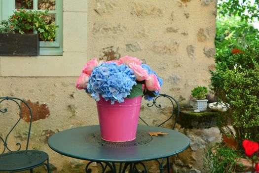Bouquet of pink roses and blue hydrangea in a pot on the table