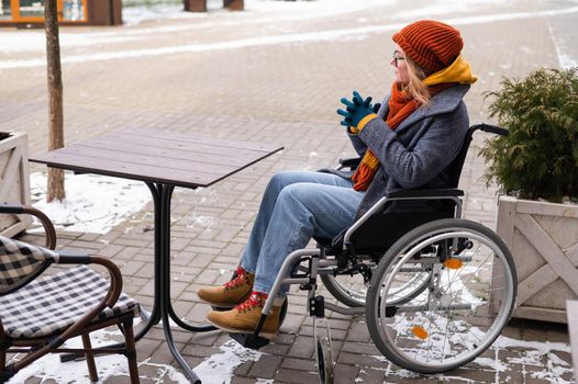 Caucasian woman in wheelchair sitting at outdoor cafe table