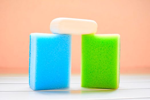 The disturbed water or air behind a moving boat or aircraft or the sound made by this.Two colored sponges and white soap for cleaning. High quality photo