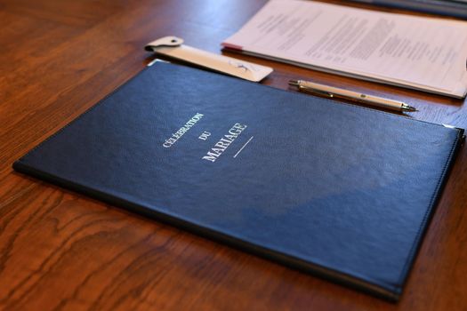Blue wedding register at a wooden table.