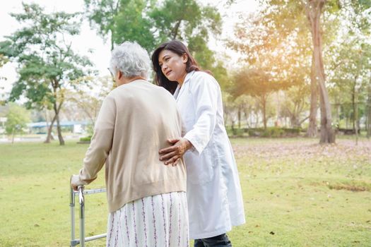 Help and care Asian senior or elderly old lady woman use walker with strong health while walking at park in happy fresh holiday.