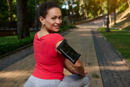 Charming middle aged fit woman in tight sportswear exercising outdoor. Sport, fitness, active lifestyle concept