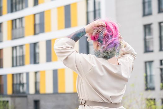 Portrait of a middle-aged woman with multi-colored hair walks on the streets of the city