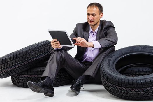 Car dealer man over tire tire background. Auto maintenance.
