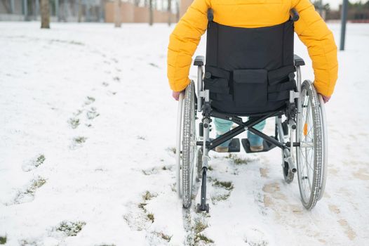 Cropped frame of a woman in a wheelchair in winter